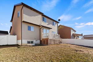 Rear view of house featuring a yard and a deck