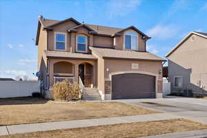 View of front of property featuring a garage, central air condition unit, and covered porch