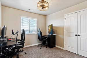 Office area with carpet and a notable chandelier