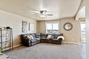 Living room with a textured ceiling and ceiling fan