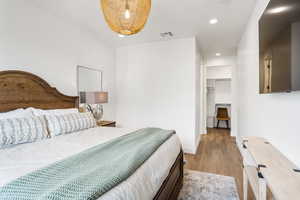 Bedroom with a closet, light wood-type flooring, and a spacious closet