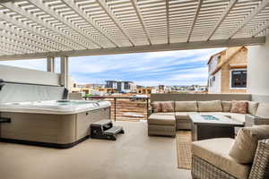 View of patio featuring an outdoor living space, a pergola, and a hot tub