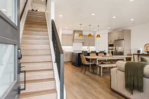 Stairs featuring sink and hardwood / wood-style flooring