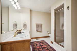 Bathroom with tile patterned floors, toilet, an enclosed shower, and vanity