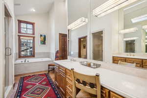 Bathroom with vanity, plus walk in shower, and high vaulted ceiling