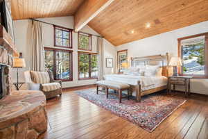 Bedroom with wood ceiling, beam ceiling, high vaulted ceiling, a fireplace, and wood-type flooring