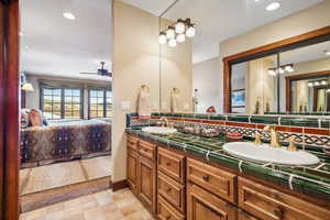 Bathroom with tasteful backsplash, ceiling fan, and vanity