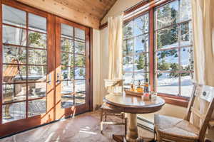 Interior space with vaulted ceiling, wooden ceiling, and baseboard heating