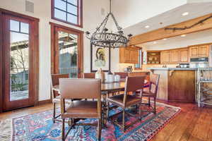 Dining space with beam ceiling, dark wood-type flooring, and a high ceiling