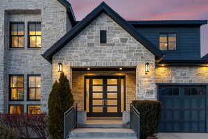 Exterior entry at dusk with a garage and french doors