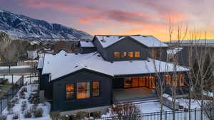 Snow covered rear of property with a mountain view