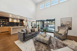 Living room with sink, light hardwood / wood-style flooring, and a high ceiling