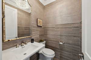 Bathroom featuring sink, backsplash, and toilet