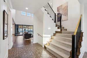 Stairs featuring hardwood / wood-style flooring and a high ceiling