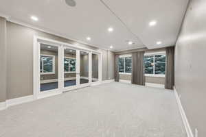 Unfurnished room featuring ornamental molding, light colored carpet, and french doors