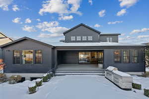 Snow covered house with exterior kitchen and a porch