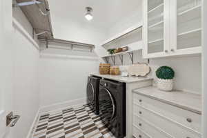 Clothes washing area with crown molding and separate washer and dryer