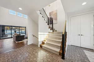 Stairway featuring a towering ceiling