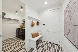 Mudroom with crown molding and washing machine and clothes dryer