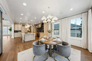 Dining area featuring ornamental molding, hardwood / wood-style floors, and a notable chandelier