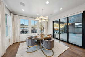 Dining room featuring crown molding, dark wood-type flooring, and plenty of natural light