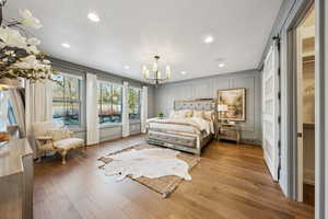 Bedroom featuring hardwood / wood-style floors, a notable chandelier, and a barn door