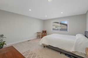 Spacious Primary Bedroom featuring a lot of natural light and light colored carpet