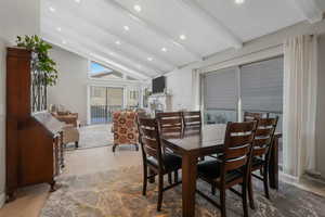 Dining room with vaulted ceiling with beams