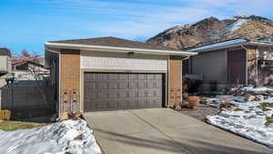 View of snow covered exterior with a mountain view and a garage