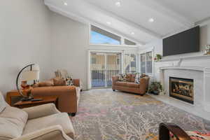 Living room featuring a high end fireplace and lofted ceiling with beams