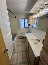 Bathroom featuring vanity, a textured ceiling, and toilet