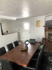 Dining space featuring a fireplace, ornamental molding, and a textured ceiling