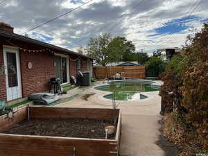 View of swimming pool with area for grilling and a patio area