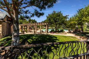 Surrounding community featuring a pool, a lawn, and a pergola