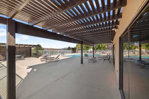 View of patio with a community pool and a pergola