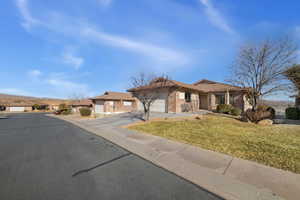 Ranch-style house featuring a garage and a front yard