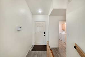 Corridor featuring washing machine and dryer and light hardwood / wood-style flooring