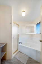 Bathroom featuring hardwood / wood-style floors and separate shower and tub