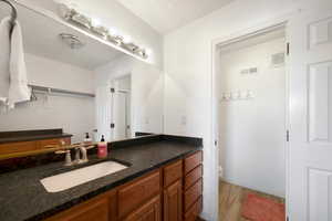 Bathroom featuring hardwood / wood-style flooring, vanity, a textured ceiling, and toilet