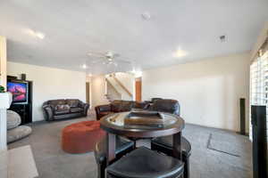 Living room with a textured ceiling, ceiling fan, and carpet