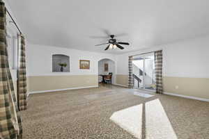 Unfurnished living room featuring ceiling fan