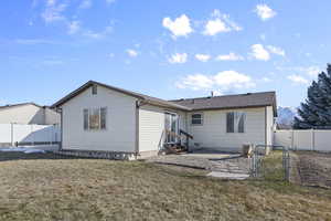 Back of house with a yard and a patio