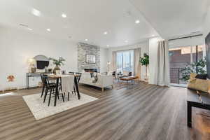 Dining space featuring a stone fireplace and dark wood-type flooring