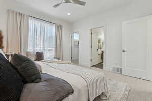 Bedroom with ceiling fan, ensuite bath, and carpet floors