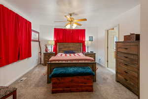 Carpeted bedroom featuring ceiling fan