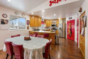 Dining room with dark wood-type flooring, sink, and lofted ceiling