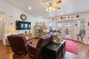 Living room with wood-type flooring, ceiling fan, and french doors