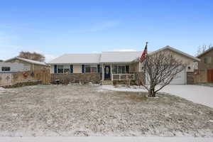 Single story home with a porch and a garage