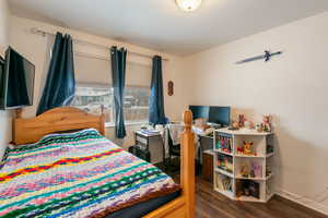 Bedroom with dark hardwood / wood-style flooring