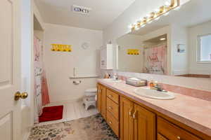 Bathroom with toilet, vanity, a shower with curtain, and tile patterned flooring